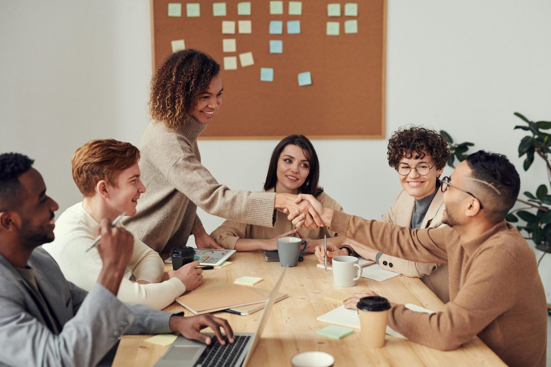 Vielfältiges Team, das in einer Besprechung zusammenarbeitet und Teamarbeit und Zusammenarbeit an einem modernen Arbeitsplatz demonstriert.
