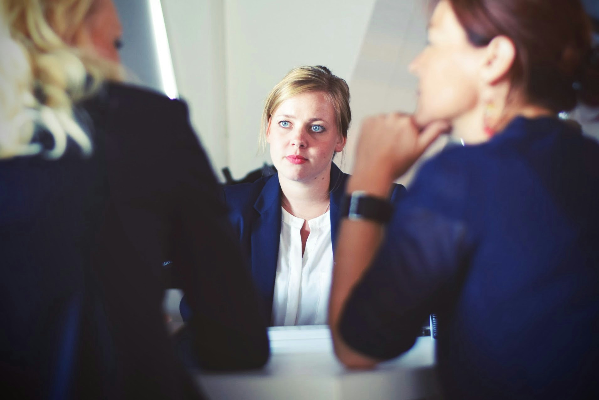 Drei Frauen sitzen neben dem Tisch